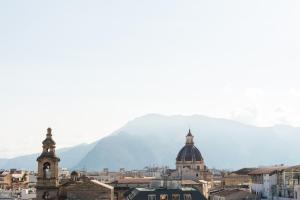 a view of a city with a mountain in the background at Vista sulle Cupole by Wonderful Italy in Palermo