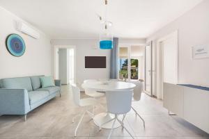 a white living room with a table and a couch at Villa Amoenitas by Perle di Puglia in Ugento