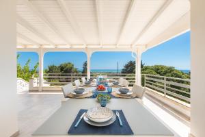 a dining room with a table and views of the ocean at Villa Amoenitas by Perle di Puglia in Ugento