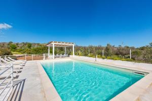 a swimming pool with chairs and a gazebo at Villa Amoenitas by Perle di Puglia in Ugento