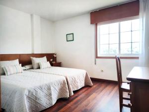 a bedroom with two beds and a window at Desconectaengalicia El Pescador, vistas al puerto, 200m playa in Portonovo