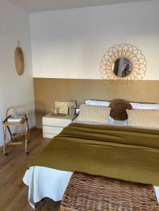 um quarto com uma cama grande e um espelho em B&B Jadis et Naguère em Noduwez