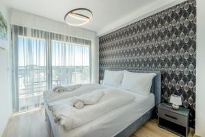 een slaapkamer met een groot bed en een groot raam bij MF Top Panorama 908 Apartment in Siófok