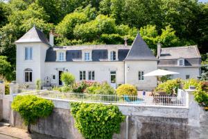 ein großes weißes Haus mit einem Garten und einer Terrasse in der Unterkunft Le Clos Eugenie - Charmante maison avec jardin et vue sur la Loire in Gennes