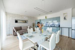 een eetkamer en een woonkamer met een witte tafel en stoelen bij MF Top Panorama 908 Apartment in Siófok