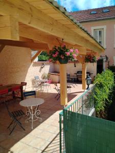 a wooden pergola with a table and chairs on a patio at Rose des Alpes in Serres