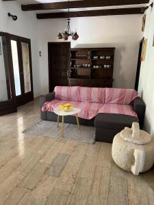 a living room with a pink couch and a table at Holiday Home Božo in Korčula