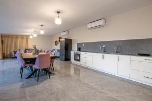 cocina y comedor con mesa y sillas en Moses Luxury Vacation Homes-מתחם פיניקס en Safed