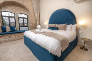 a bedroom with a large bed with a blue headboard at Moses Luxury Vacation Homes-מתחם פיניקס in Safed