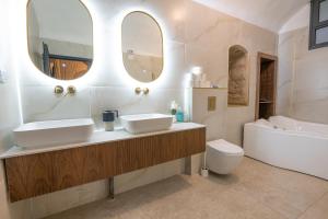 a bathroom with two sinks and a tub and a toilet at Moses Luxury Vacation Homes-מתחם פיניקס in Safed