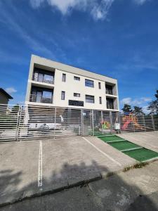 a white building with a tennis court in front of it at Analeya in Eforie Nord
