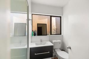 W łazience znajduje się umywalka, toaleta i lustro. w obiekcie Small Wallet-Friendly Private Room in a 7 BR Shared House - The Ben's Room 6 w mieście Queenstown