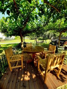 einen Holztisch und Stühle auf einer Terrasse unter einem Baum in der Unterkunft Luxury House Papadimitriou in Asprovalta