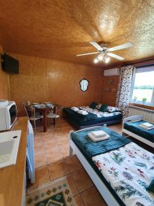a room with two beds and a kitchen with a table at Szyszkowy Domek in Milejczyce