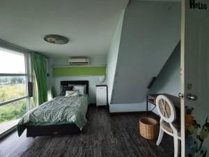 a bedroom with a bed with a green comforter at Summer Cottage Apartel in Bangkok