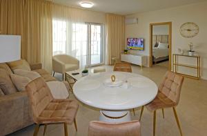 un soggiorno con divano, tavolo e sedie di Apartament Sea Star a Pogorzelica