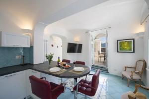 cocina y sala de estar con mesa y sillas en Le Suites della Principessa, en Ravello