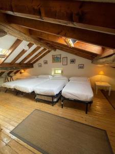 four beds in a room with wooden floors and ceilings at LA CASONA DE DON ELÍAS in Silió