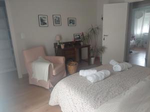 a bedroom with two towels on a bed and a chair at Casa rural el atardecer in Belchite