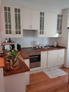 una cocina con armarios blancos y fregadero en Casa rural el atardecer, en Belchite