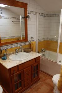 a bathroom with a sink and a tub and a mirror at O BARCO DE VALDEORRAS LUZ Y ALEGRÍA in O Barco de Valdeorras