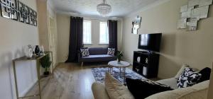a living room with a couch and a tv at Dreals Apartments in Stevenage