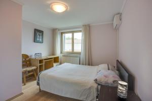 Un dormitorio con una cama y un escritorio y una ventana. en Holiday House Planik, en Brest
