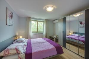 1 dormitorio con cama morada y espejo en Holiday House Planik, en Brest 37 fotos más