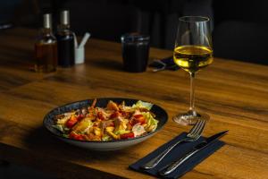 a bowl of food and a glass of wine on a table at Moro Inn in Korčula