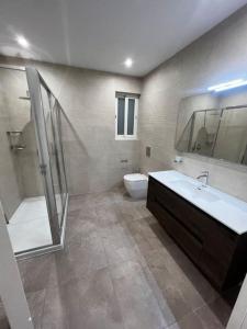a bathroom with a tub and a sink and a toilet at Zejtun 3-Bedroom Modern Apartment in Żejtun