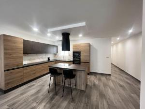 a kitchen with a wooden table and two stools at Zejtun 3-Bedroom Modern Apartment in Żejtun