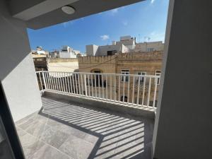 a balcony with a view of a building at Zejtun 3-Bedroom Modern Apartment in Żejtun