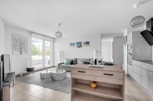 uma cozinha e sala de estar com um sofá e uma mesa em La Marquette - Appartement avec balcon em Toulouse