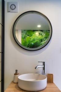 a bathroom sink with a round mirror on the wall at luxury dome tents ikaria ap'esso in Raches