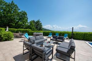 a patio with couches and chairs and a table at Villa Sveti Petar - with heated pool and outdoor jacuzzi in Opatija