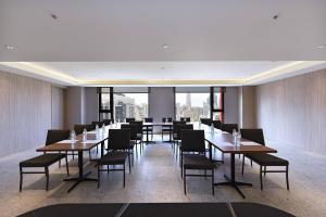 un comedor con mesas y sillas y una gran ventana en Fullon Poshtel - Kaohsiung en Kaohsiung