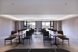 a dining room with tables and chairs and a large window at Fullon Poshtel - Kaohsiung in Kaohsiung