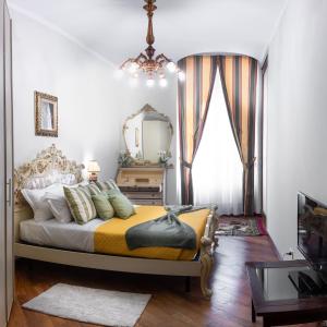 Schlafzimmer mit einem Bett mit einem Spiegel und einem Fenster in der Unterkunft Sansedoni - Luxury in Siena