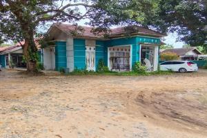 une maison bleue avec une voiture garée devant elle dans l'établissement SPOT ON 92648 Wisma Padi Syariah Panyipatan, 