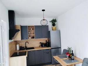 cocina con armarios azules y mesa de madera en Apartment Aurora, en Hvar