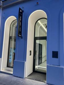 niebieski budynek z trzema oknami i drzwiami w obiekcie Fesh Lofts w Wiedniu