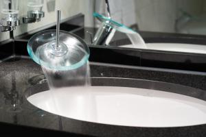 a glass is sitting on a bathroom sink at AcarA das Penthouse Hotel in Oldenburg