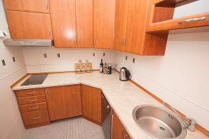 a kitchen with wooden cabinets and a sink at Plava Vila Beach Apartments Sveti Stefan in Sveti Stefan
