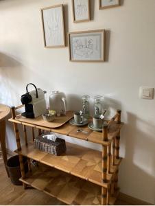uma mesa de madeira com chávenas e electrodomésticos em B&B Jadis et Naguère em Noduwez