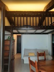 a living room with a loft bed and a couch at Grand studio 35 m2 avec mezzanine et vue mer in Théoule-sur-Mer