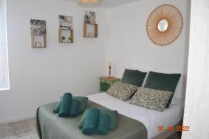 a bedroom with a bed with blue pillows and a mirror at Le Quatorze in Bollène