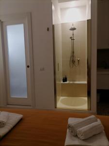 a bathroom with a shower with two towels on a bed at Casa Quieta in Marina di Camerota