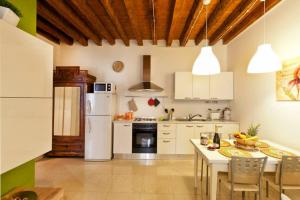 a kitchen with a table and a white refrigerator at Appartamenti Sofia & Marilyn in Castelfranco Veneto