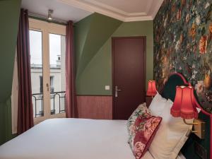 パリにあるオテル ブリッタニーのベッドルーム1室(ベッド1台付)が備わります。壁には絵画が飾られています。