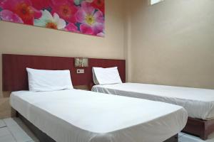 - 2 lits dans une chambre ornée d'une peinture murale dans l'établissement SPOT ON 92648 Wisma Padi Syariah Panyipatan, 